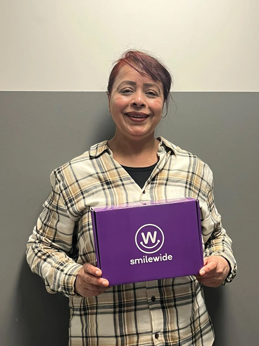 SmileWide community member holding a SmileWide package
