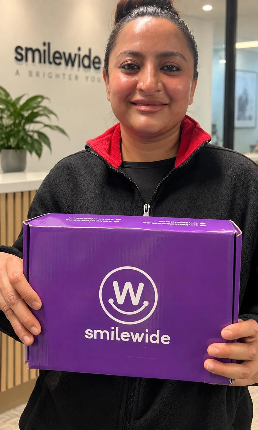 SmileWide community member holding a SmileWide package
