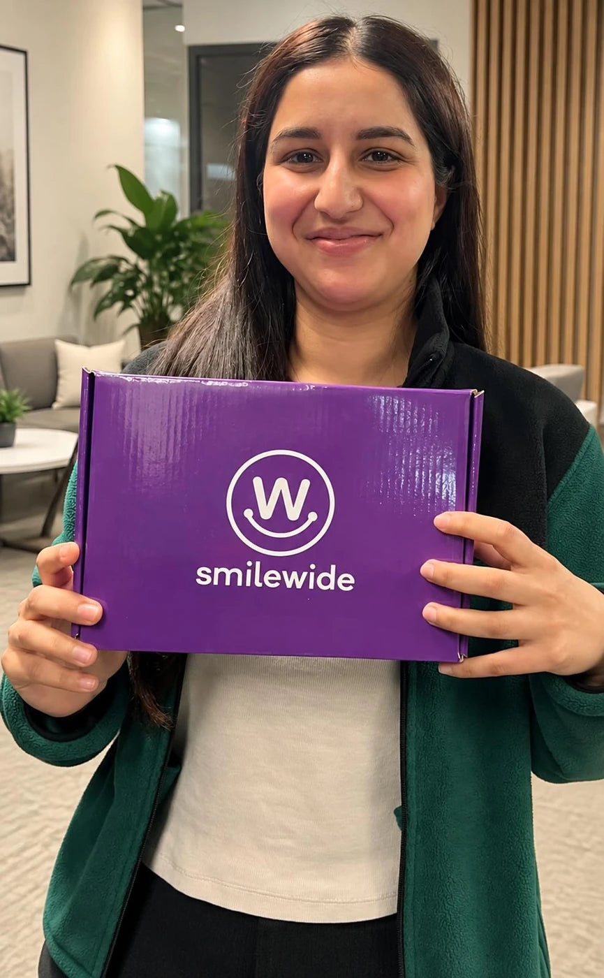 SmileWide community member holding a SmileWide package