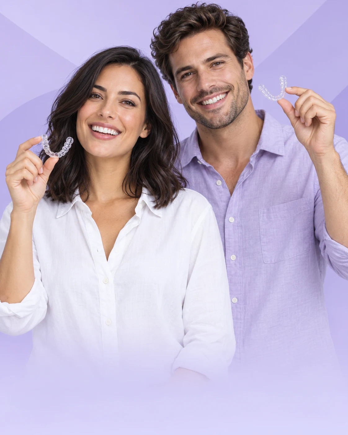 Smiling adults holding clear aligners near their faces